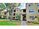 Condo building with a yellow facade, black balconies, and lush landscaping around the building at 2586 Robert Trent Jones Dr # 1124, Orlando, FL 32835