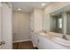 Bathroom featuring dual sinks, a white vanity, tile flooring, and a shower with tile surround at 4106 Gerbera Daisy Ave, Lake Hamilton, FL 33851