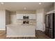 Bright kitchen featuring white cabinetry, stainless steel appliances, and an island with a sink at 4106 Gerbera Daisy Ave, Lake Hamilton, FL 33851