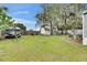 Spacious backyard with lush green grass and mature shade trees, perfect for outdoor activities at 4854 Myrtle View N Dr, Mulberry, FL 33860