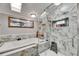 Bright bathroom featuring a luxurious tub and glass shower enclosure with marble tile at 4854 Myrtle View N Dr, Mulberry, FL 33860