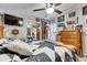 Bright bedroom featuring a cozy bed, ceiling fan, and dresser with mirror sliding closet doors at 4854 Myrtle View N Dr, Mulberry, FL 33860