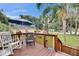 Inviting front porch with outdoor seating, shaded by trees, and American flags waving nearby at 4854 Myrtle View N Dr, Mulberry, FL 33860