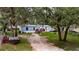 Quaint home with an American flag, a well-maintained lawn, and mature trees at 4854 Myrtle View N Dr, Mulberry, FL 33860