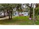 Scenic view of a home with an inviting front yard, flags, and mature trees at 4854 Myrtle View N Dr, Mulberry, FL 33860