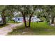 Charming home featuring a green lawn, mature trees, and an American flag at 4854 Myrtle View N Dr, Mulberry, FL 33860
