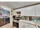 Well-lit kitchen with white cabinets and stainless steel appliances near laundry room at 4854 Myrtle View N Dr, Mulberry, FL 33860