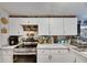 Kitchen boasts white cabinets, stylish countertops, and stainless steel appliances at 4854 Myrtle View N Dr, Mulberry, FL 33860