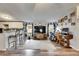 Open-concept living space featuring a large television, wood-look floors, and a home office setup at 4854 Myrtle View N Dr, Mulberry, FL 33860