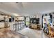 Bright living area flows into a kitchen with counter seating, stainless steel appliances, and wood-look flooring at 4854 Myrtle View N Dr, Mulberry, FL 33860