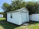 Exterior view of a storage shed with a garage door, nestled in a tranquil backyard setting at 5316 Dorman Rd, Lakeland, FL 33813