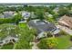 Aerial view of a home with a screened pool, spacious yard, mature trees, and lake in the distance at 1034 Brighton Way, Lakeland, FL 33813