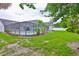 Green grass backyard with a screened in pool at 1034 Brighton Way, Lakeland, FL 33813