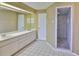 Bathroom showcasing a double vanity and walk-in shower with decorative stone flooring at 1034 Brighton Way, Lakeland, FL 33813