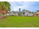 Well-maintained, light-gray home with a vibrant green lawn, palm trees, and a bright blue front door at 1034 Brighton Way, Lakeland, FL 33813