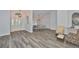 Spacious living room with stylish gray wood flooring, an arched entry, and a view of the dining area at 1034 Brighton Way, Lakeland, FL 33813