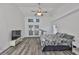 Bright main bedroom with wood-look flooring, ceiling fan, French doors, and two windows providing natural light at 1034 Brighton Way, Lakeland, FL 33813