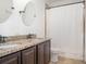 Bathroom featuring double vanity sinks with granite countertops and a shower with tan tile at , Kissimmee, FL 34758