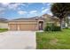 Charming single-story home with a well-manicured lawn, two-car garage, and inviting stone-accented entrance at , Kissimmee, FL 34758