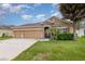 Inviting single-story home with a two-car garage, fresh green lawn, and stone accent entrance at , Kissimmee, FL 34758