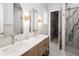 Bright bathroom featuring double vanity with white countertop, decorative mirrors and tiled shower at 2242 Soaring Eagle Pl, Lake Mary, FL 32746