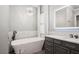 This bathroom has a soaking tub, a chandelier, and a single sink vanity with an LED mirror at 2242 Soaring Eagle Pl, Lake Mary, FL 32746