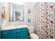 Stylish bathroom with a turquoise vanity, shower, silver framed mirror and floral shower curtain at 2242 Soaring Eagle Pl, Lake Mary, FL 32746
