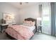 Cozy bedroom with a patterned duvet cover, stylish furniture, and a light-filled window at 2242 Soaring Eagle Pl, Lake Mary, FL 32746