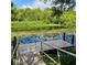 Picturesque view of a wooden dock on a serene lake with lily pads and lush greenery at 2242 Soaring Eagle Pl, Lake Mary, FL 32746