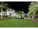 Exterior elevation of the home showcasing the lawn, palm trees, and architectural details during the night at 2242 Soaring Eagle Pl, Lake Mary, FL 32746