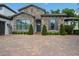 Charming front entrance with a stone facade, manicured landscaping, and a brick paver driveway creating an inviting approach at 2242 Soaring Eagle Pl, Lake Mary, FL 32746
