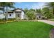 Beautifully landscaped front yard featuring a well-manicured lawn, lush greenery, and elegant stone accents on the home's facade at 2242 Soaring Eagle Pl, Lake Mary, FL 32746