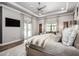 The main bedroom includes wood floors, a ceiling fan, french doors, and a flat screen TV at 2242 Soaring Eagle Pl, Lake Mary, FL 32746