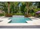 Beautiful pool with a waterfall feature and travertine deck surrounded by lush landscaping at 2242 Soaring Eagle Pl, Lake Mary, FL 32746