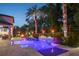 A luxurious pool area illuminated at twilight with tropical landscaping and accent lighting at 2242 Soaring Eagle Pl, Lake Mary, FL 32746
