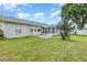 Expansive backyard shows the home's exterior, a screened-in porch and well manicured lawn at 216 Kingshill Se Ct, Winter Haven, FL 33884