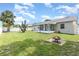 Lush backyard showing a fire pit, white fence, large yard and screened in porch at 216 Kingshill Se Ct, Winter Haven, FL 33884