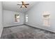 Spacious bedroom with neutral carpet, three windows, and ceiling fan providing great lighting and comfort at 216 Kingshill Se Ct, Winter Haven, FL 33884