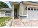 Inviting covered front entry with a brick walkway, exterior lighting, and manicured landscaping at 216 Kingshill Se Ct, Winter Haven, FL 33884