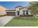 Charming single-Gathering home with a well-manicured lawn, two-car garage, and blue front door at 3067 Princewood Dr, Minneola, FL 34715