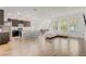 Open concept kitchen, dining, and living area with ample natural light and wood-look tile flooring at 3067 Princewood Dr, Minneola, FL 34715