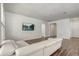 Bright living room with wood-look tile, white walls, and comfortable white couch at 3067 Princewood Dr, Minneola, FL 34715