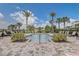 Community pool with lounge chairs, manicured landscaping, and a clear blue sky at 3067 Princewood Dr, Minneola, FL 34715