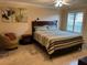 Comfortable bedroom featuring a bed with a striped cover, sconce lighting, and a side chair at 310 Knoll Pl, The Villages, FL 32162