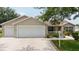 Charming single-story home featuring a two-car garage, well-maintained landscaping, and a welcoming facade at 310 Knoll Pl, The Villages, FL 32162