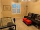 Office featuring a glass desk, a black futon, and orange footstools at 310 Knoll Pl, The Villages, FL 32162