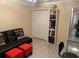 Office featuring a futon, orange footstools, and a bookcase, with an open view into another room at 310 Knoll Pl, The Villages, FL 32162