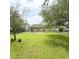 Large backyard with green lawn, patio, and black metal fence at 12844 Oulton Cir, Orlando, FL 32832