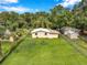 Backyard has grass, trees, and chain link fence at 1740 Inman Nw Dr, Winter Haven, FL 33881