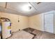 Basement featuring a water heater, concrete floor, and door at 1740 Inman Nw Dr, Winter Haven, FL 33881